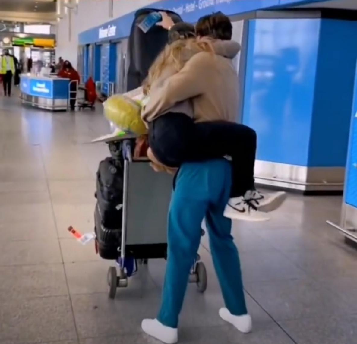 运动员刚回国被女友熊抱，单手搂住女方，摘掉口罩直接在机场热吻(2)