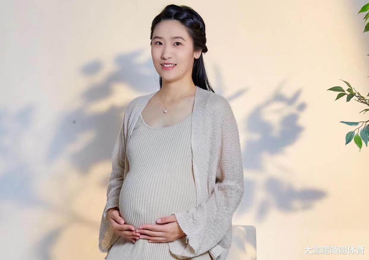 中国世界冠军即将临盆，穿网格状孕妇装，双手抚摸孕肚，韵味十足